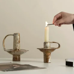 Wabi sabi clay taper candle holder on a dining table for home decor