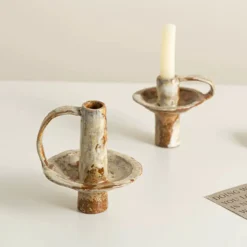 Wabi sabi clay taper candle holder on a dining table for home decor