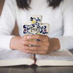 Holding porcelain cross for prayer